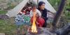 A person and child sitting by a fire after the earthquake in Nepal