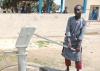 A young Christian refugee draws water from a Barnabas Aid funded bore well